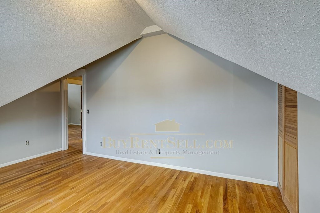 a living room with wood floors and a white wall