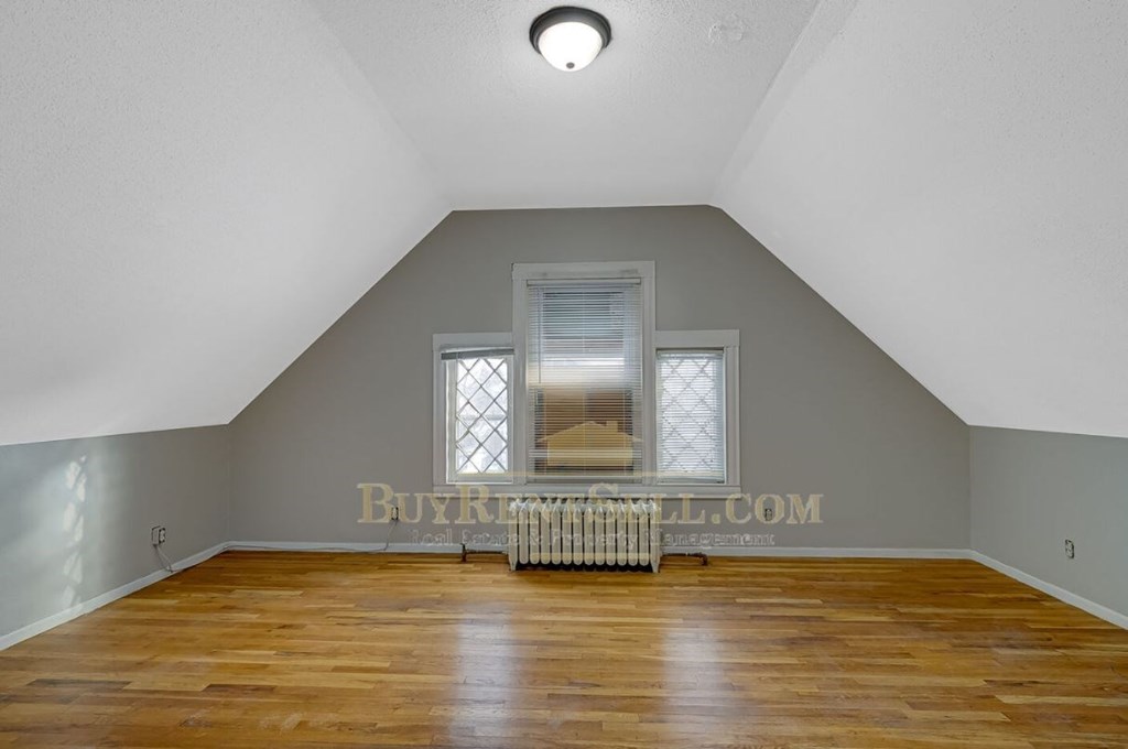 a bedroom with a vaulted ceiling and a window