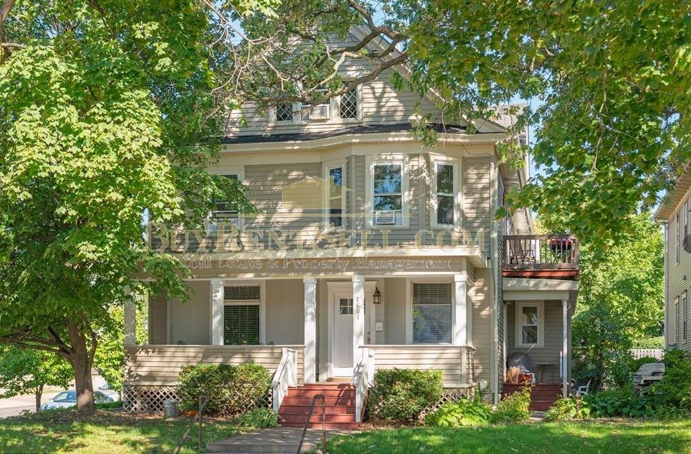 a white house with a porch and trees