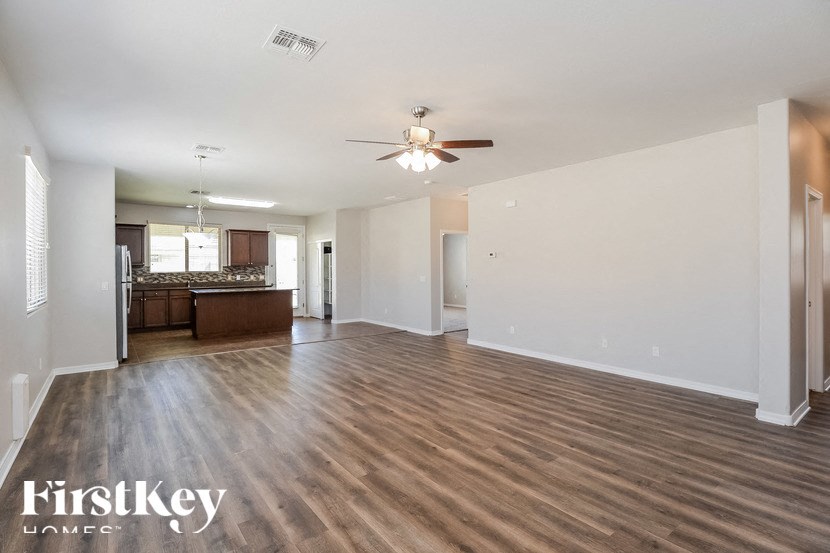 A spacious room with wooden flooring and a ceiling fan.