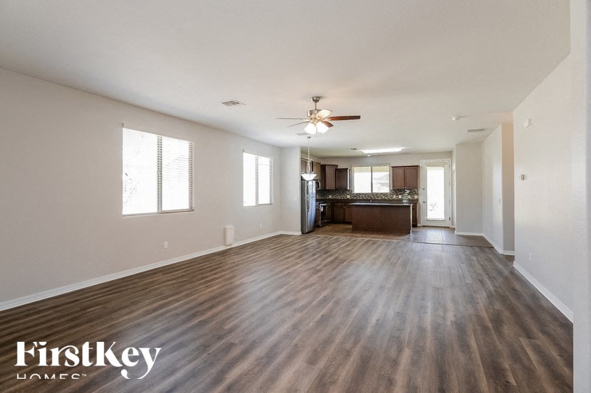 A spacious room with wooden floors and a ceiling fan.
