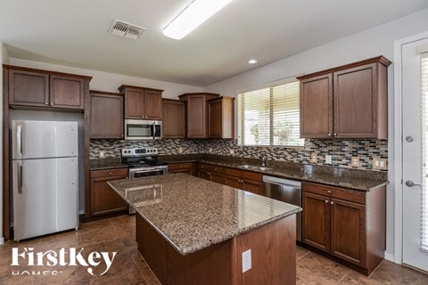 A kitchen with brown cabinets and granite countertops.