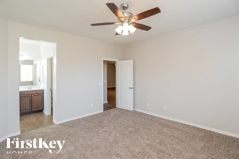 A spacious room with a ceiling fan and carpeted floor.