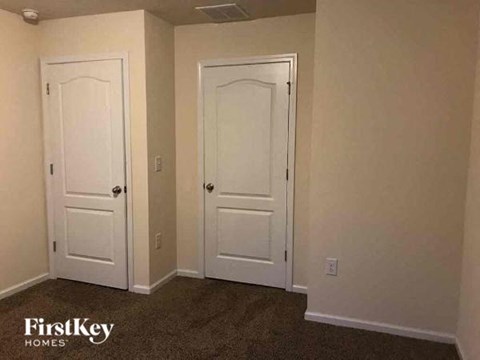 a living room with two doors and a carpet