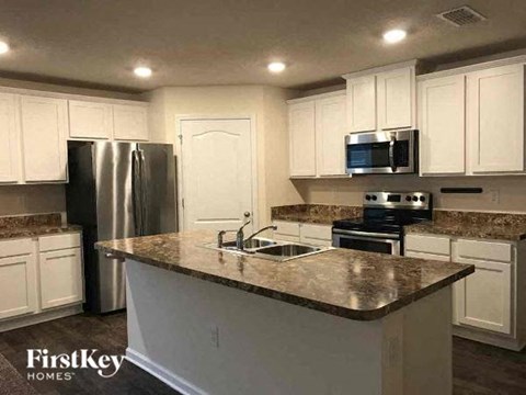 a kitchen with white cabinets and a counter top