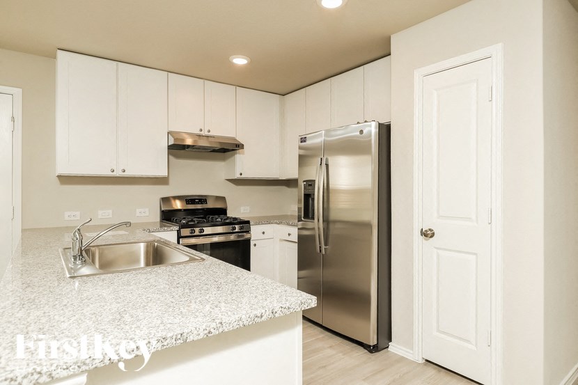 A kitchen with white cabinets and stainless steel appliances.