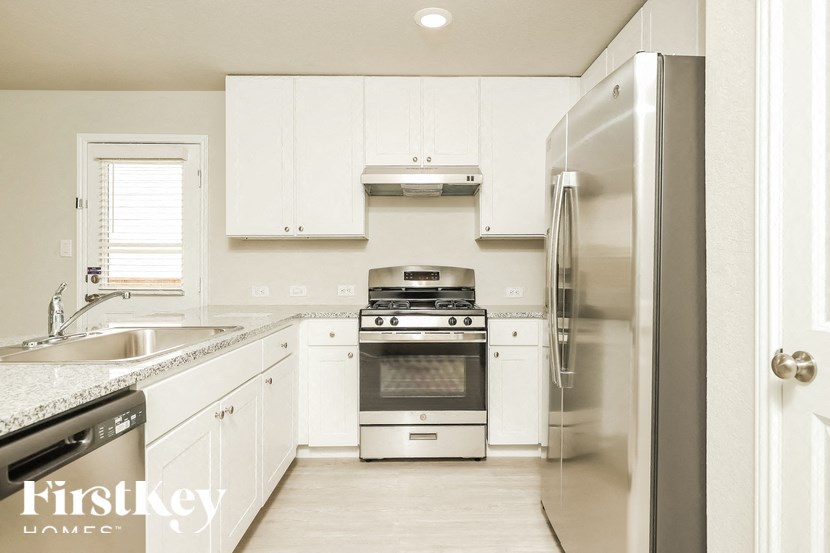 A kitchen with white cabinets and stainless steel appliances.