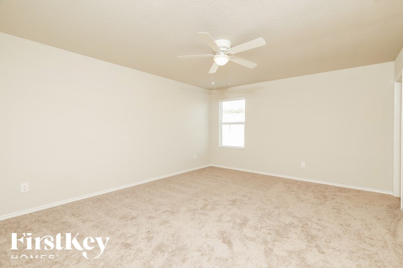 A room with a ceiling fan and a window.
