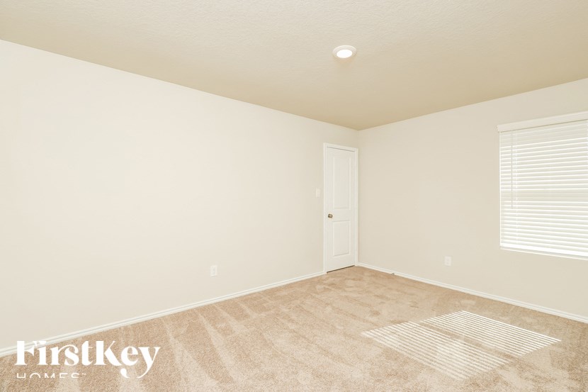 A room with a carpet, a door and a window.