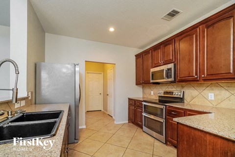 a kitchen with wooden cabinets and stainless steel appliances
