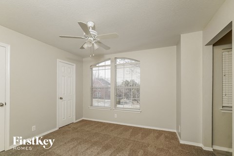 a living room with a ceiling fan and a window