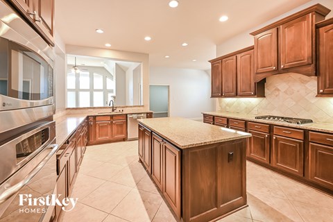 a large kitchen with wooden cabinets and stainless steel appliances