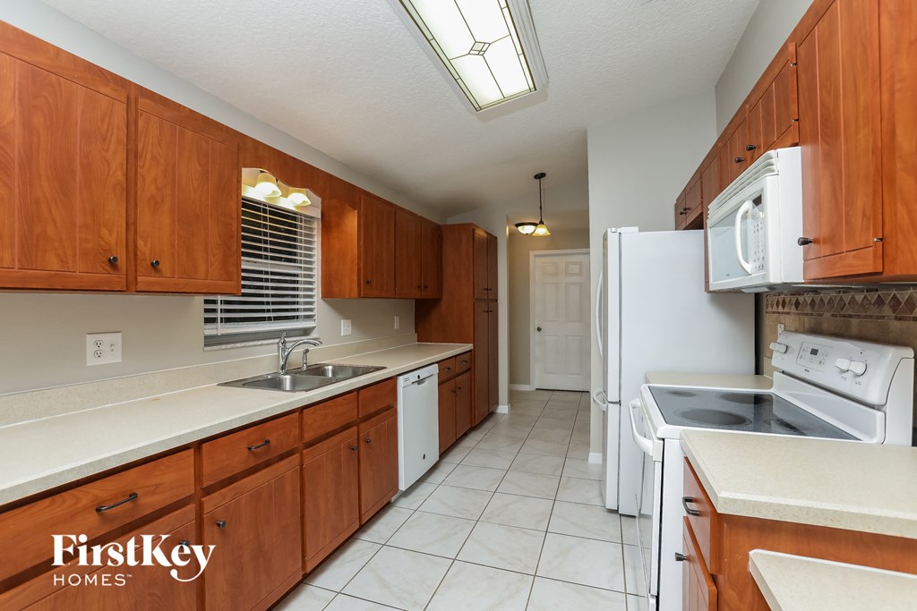 a kitchen with white appliances and wooden cabinets
