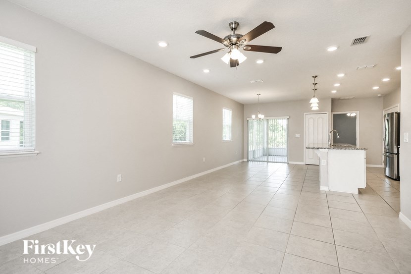 an empty kitchen and living room with a ceiling fan