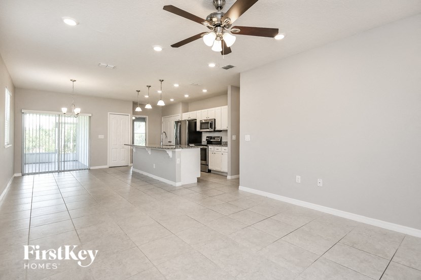 an empty kitchen and living room with a ceiling fan