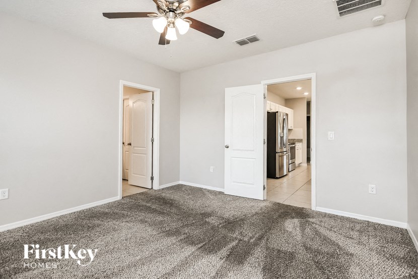an empty living room with a ceiling fan