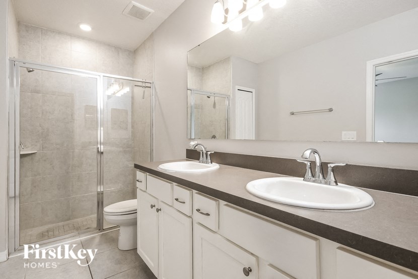 a bathroom with two sinks and a shower and a toilet