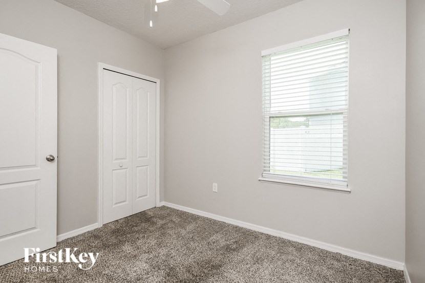 the bedroom of a home with carpet and a window
