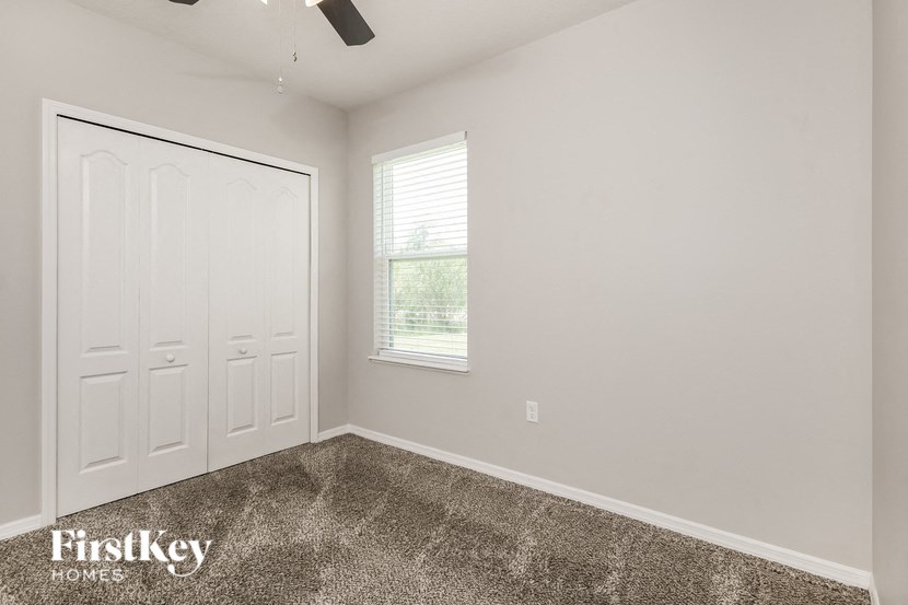 an empty room with a white door and a window