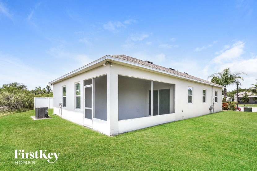a white house with a lawn and a blue sky