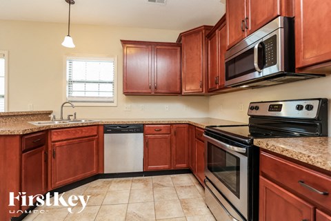 A kitchen with brown cabinets and a black stove top oven.