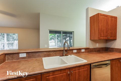 a kitchen with wooden cabinets and a sink and a window