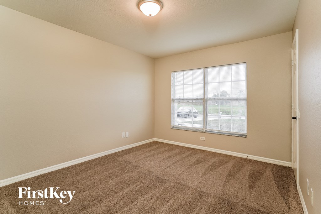 an empty living room with carpet and a window