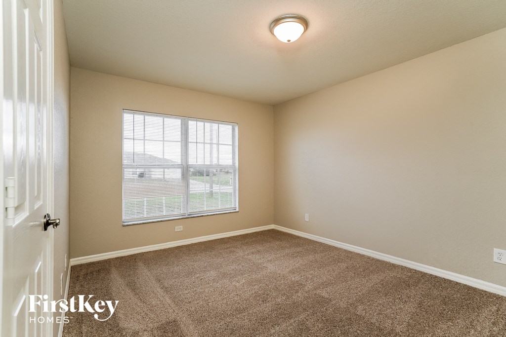 an empty living room with carpet and a large window
