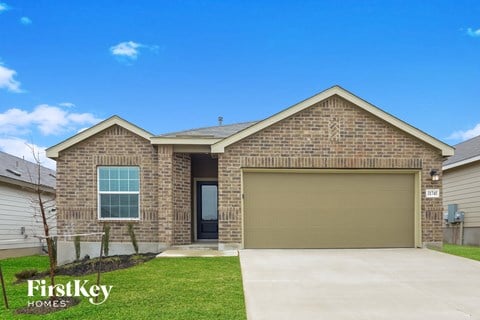 a tan brick house with a garage door