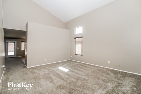 an empty living room with carpet and a window
