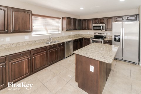 a large kitchen with stainless steel appliances and granite counter tops