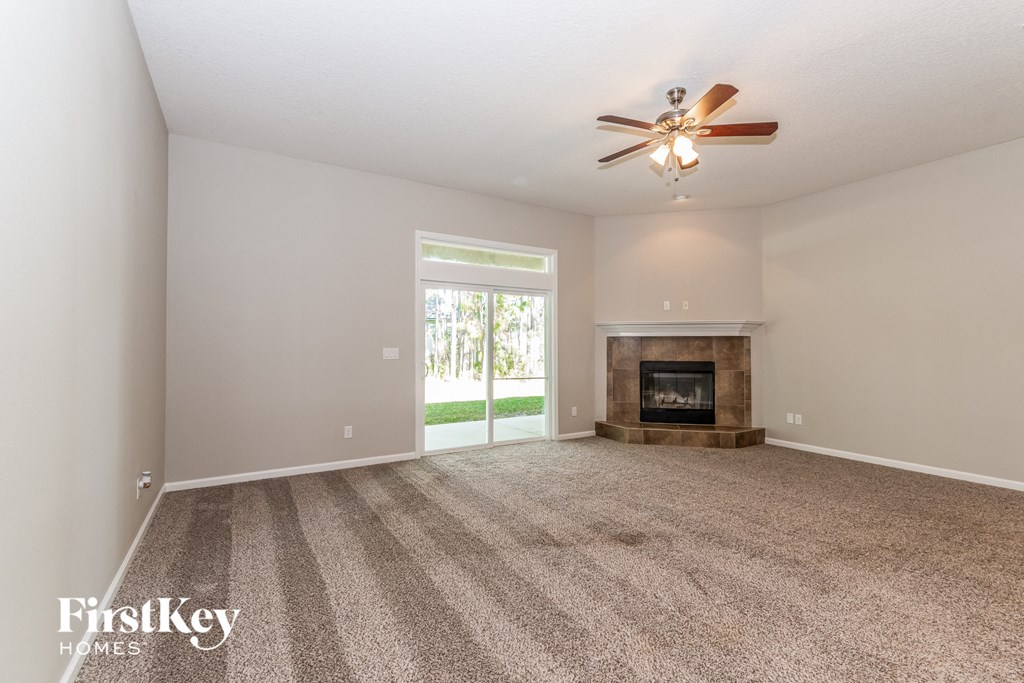 A room with a fireplace and a ceiling fan.