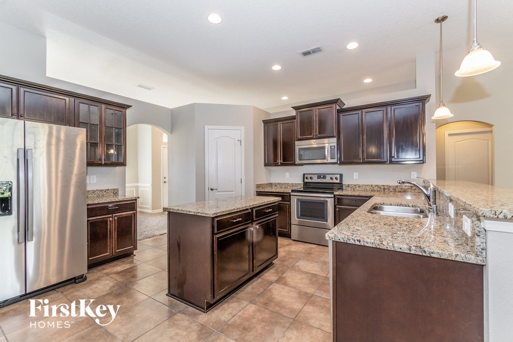 A kitchen with brown cabinets and a refrigerator.
