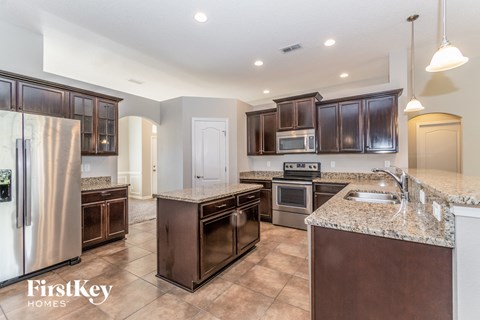 A kitchen with brown cabinets and a refrigerator.