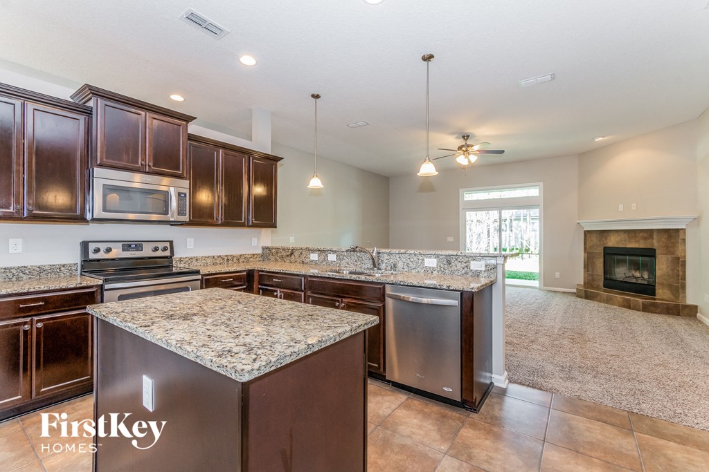 A kitchen with brown cabinets and a granite countertop.