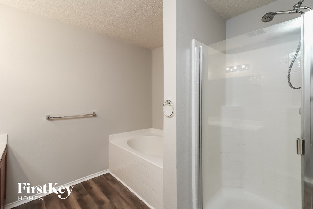 a bathroom with a shower and a tub and a sink
