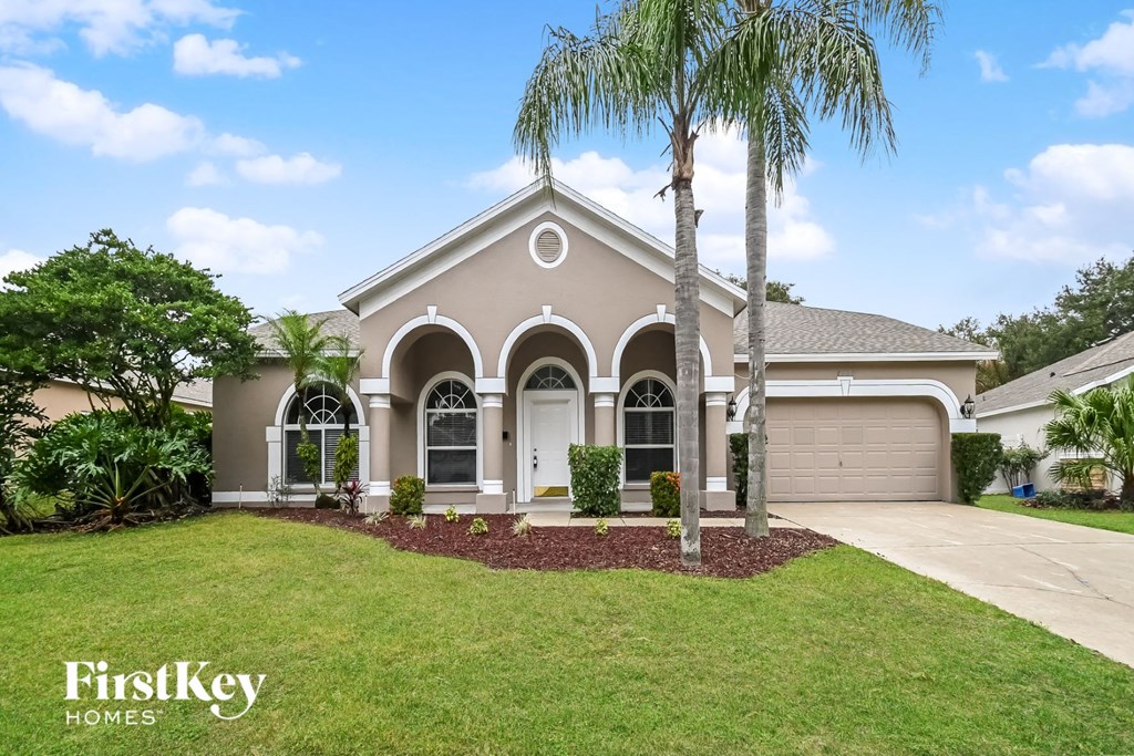 the front of a house with palm trees