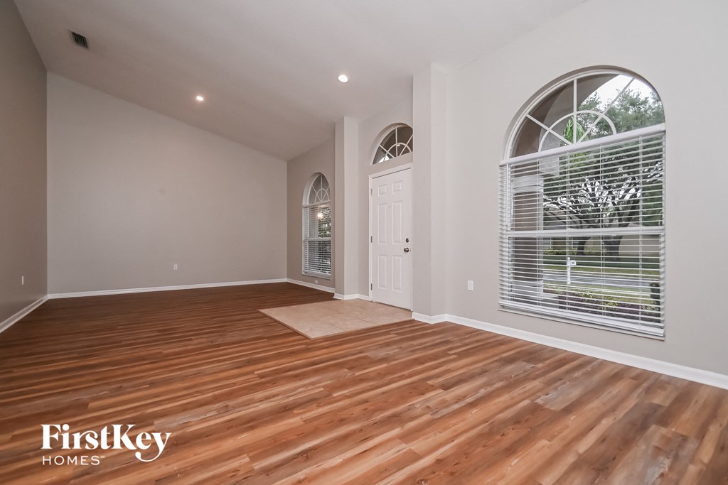 the living room with hardwood floors and a large window