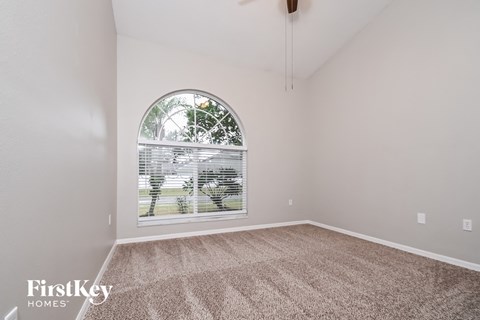 the living room of a home with a large window and carpet