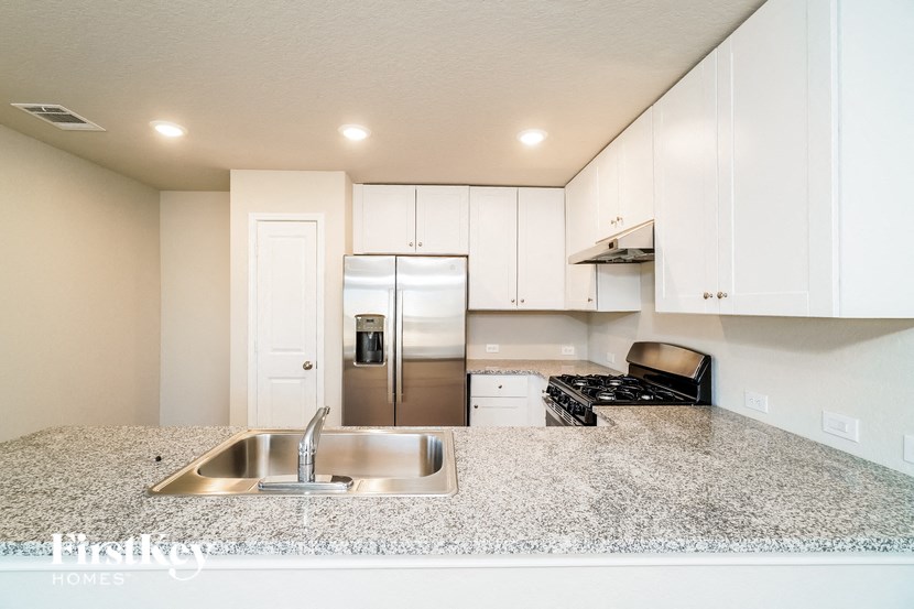 A kitchen with granite countertops and stainless steel appliances.