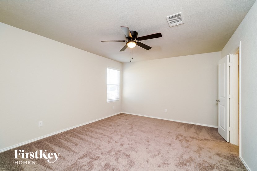 A room with a ceiling fan and a door.