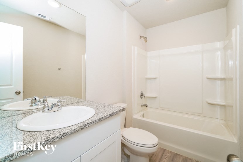 A white bathroom with a sink, toilet and bathtub.