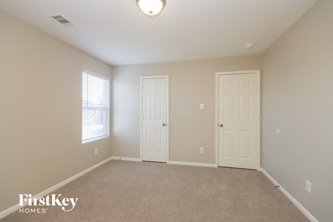 a bedroom with two doors and a carpeted floor