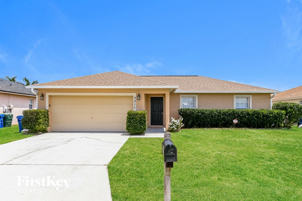 a home with a lawn and a parking meter in front of it