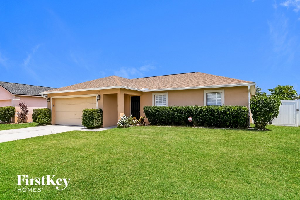a beige house with a lawn in front of it