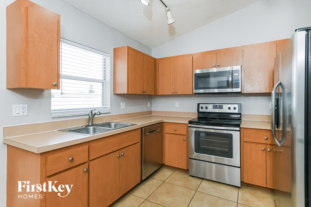 a kitchen with wooden cabinets and stainless steel appliances
