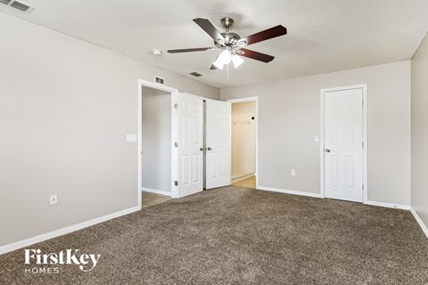 a living room with carpet and a ceiling fan