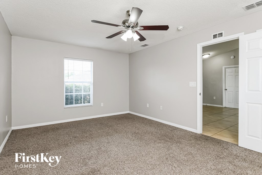the living room of an empty house with a ceiling fan