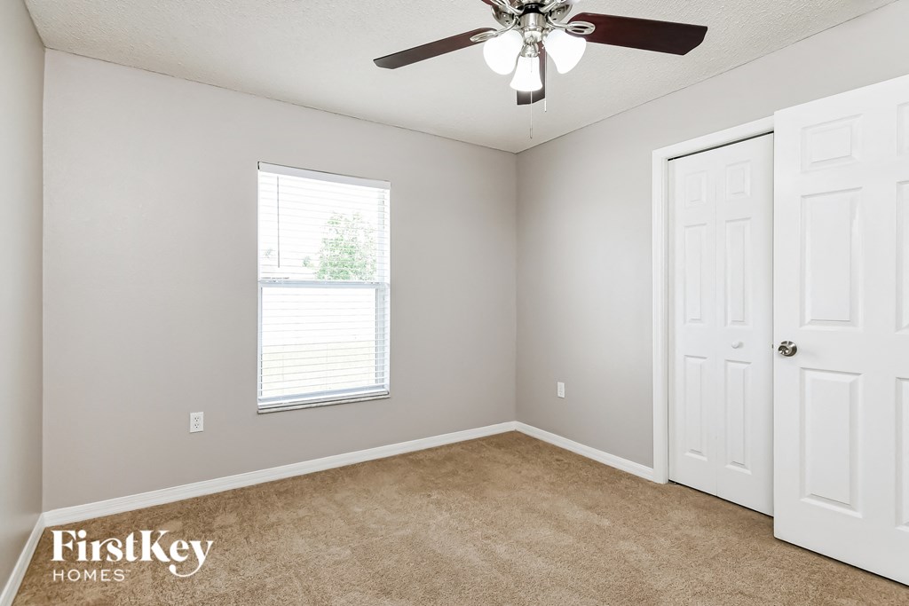 a bedroom with a ceiling fan and a window