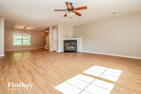 A spacious room with a fireplace and a ceiling fan.